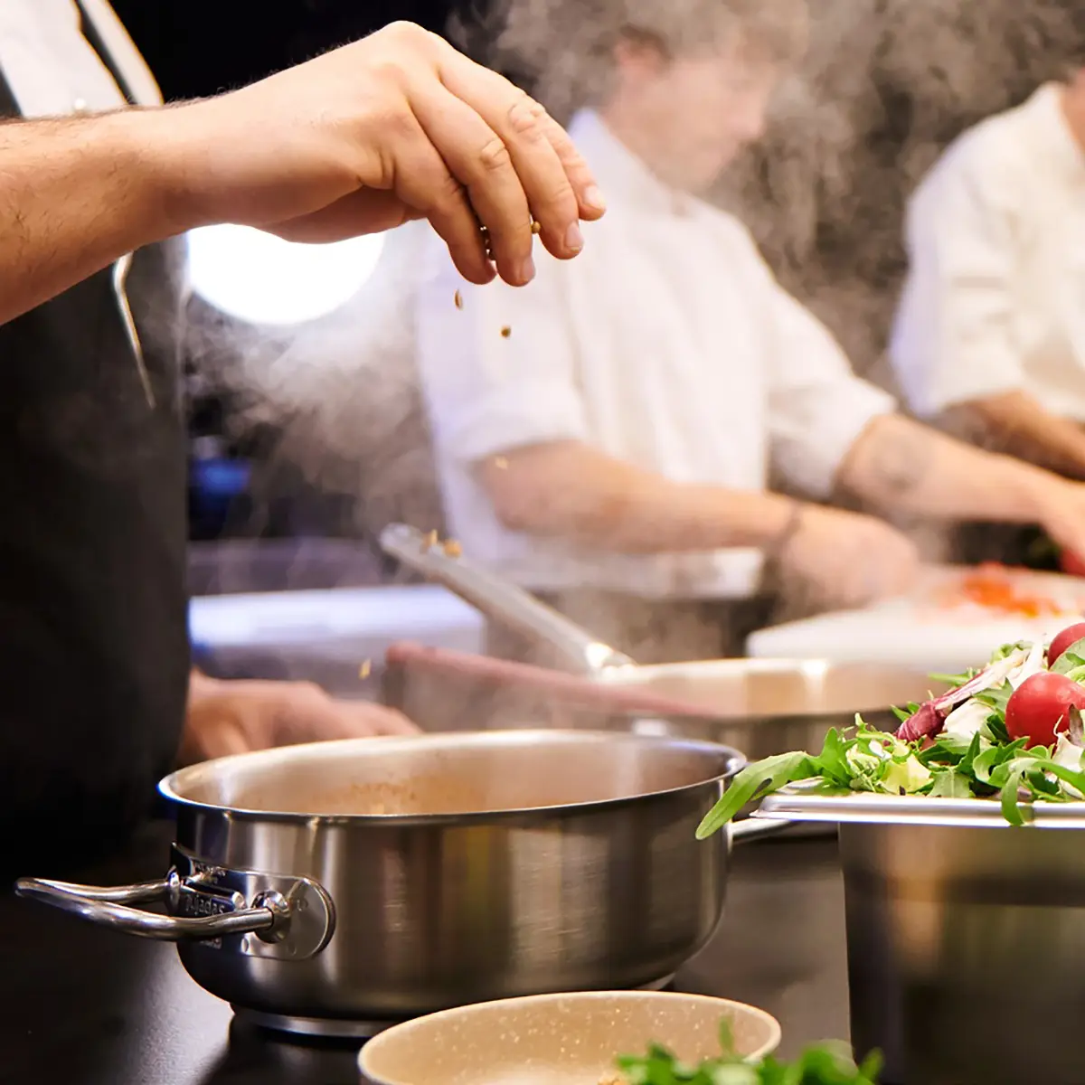 Cozinheiros a empratar com utensílios profissionais